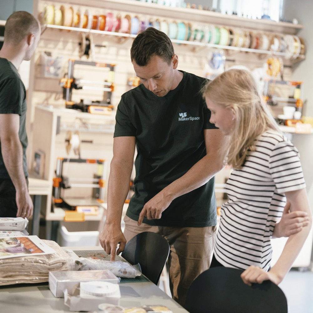 Medarbejder i Bülows MakerSpace hjælper ung med kreativt arbejde i makerspace